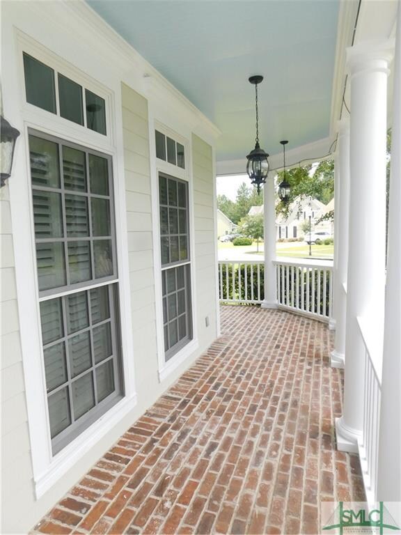 Brick wrap around front porch overlooks park area.
