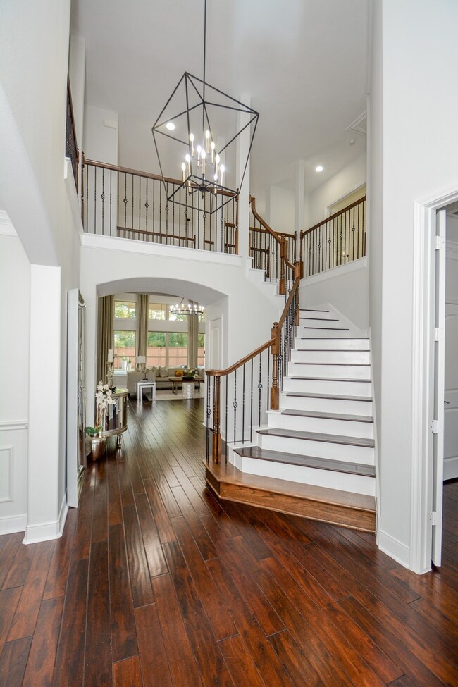 Yes! This view is surely one-of-a-kind! Dramatic, yes. Beautiful on its own, yes again! Notice the lovely, artistic contrast between the hallway's dark wood flooring and the vanilla white facing out view of the individual steps! Arched doorways, eggshell walls and beautiful, rustic chandelier light the space and make it memorable.