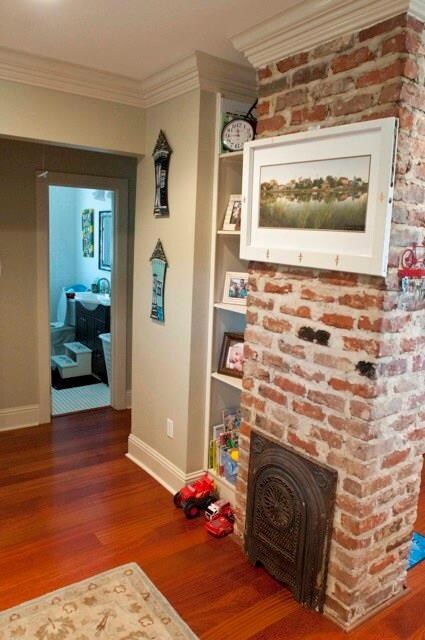Living room with built-in shelving and exposed bri