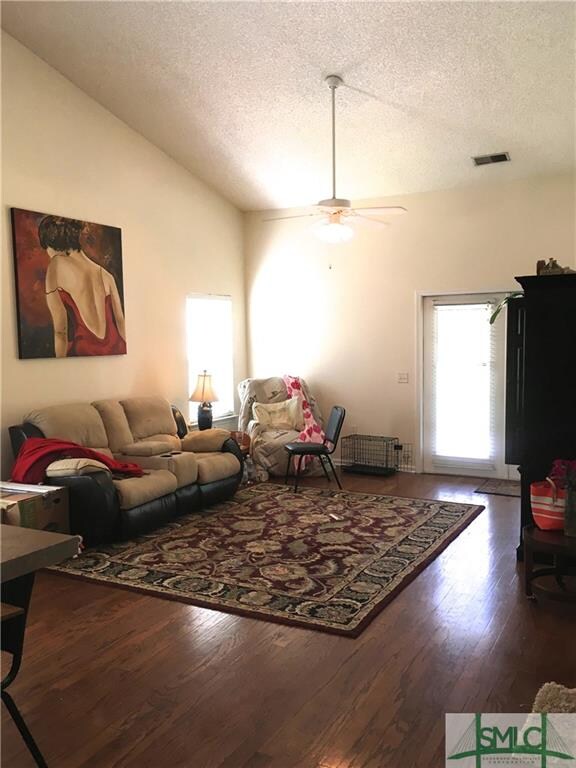 Rich, dark hardwood floors are accented by vaulted
