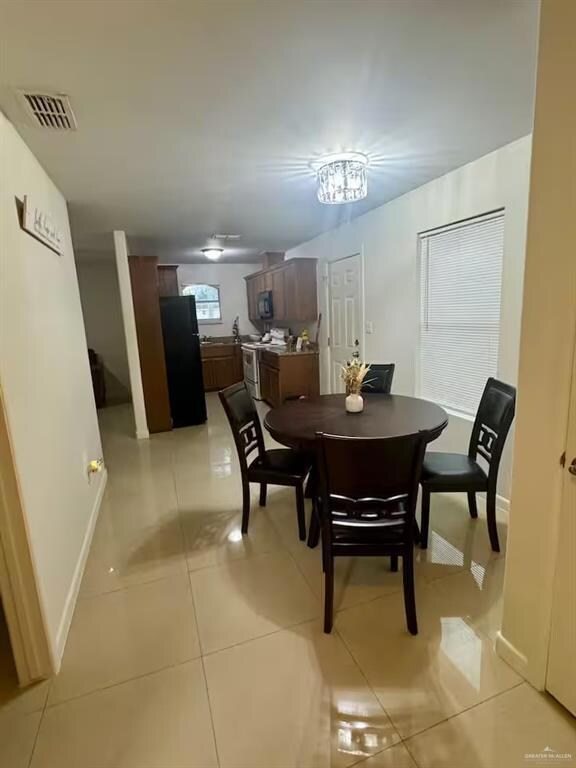 Dining space featuring light tile patterned flooring and baseboards