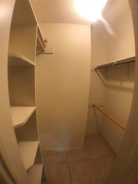 Walk in closet with tile patterned flooring