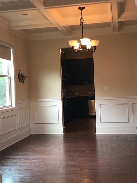 Unfurnished dining area with wainscoting, beam cei