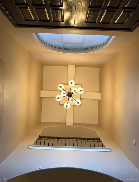 Interior details featuring a tray ceiling and a chandelier