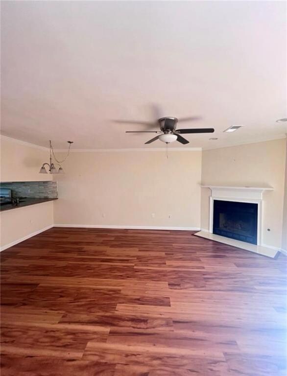 Unfurnished living room featuring crown molding, a