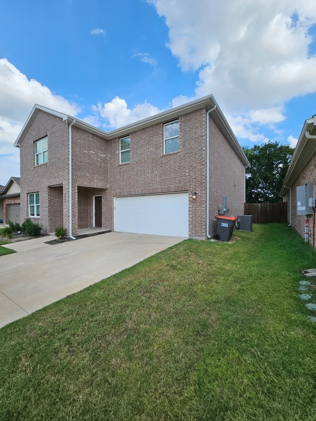View of side of home featuring brick siding, driveway, and a garage