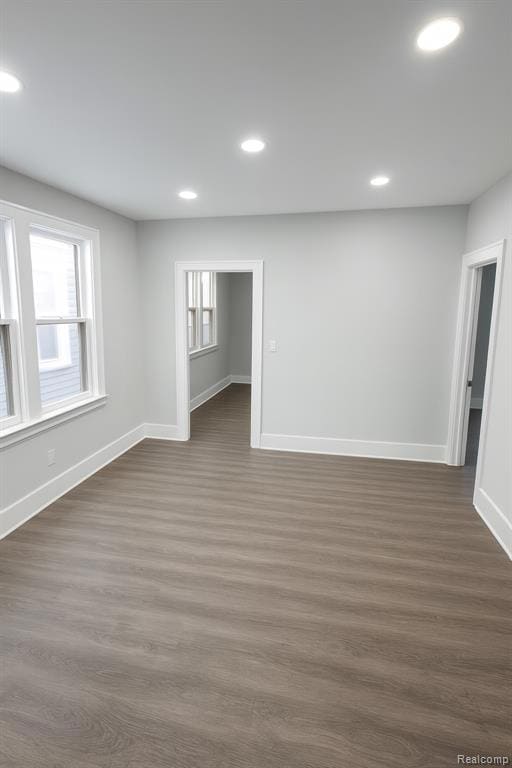 Unfurnished room with recessed lighting, dark wood-style floors, and healthy amount of natural light