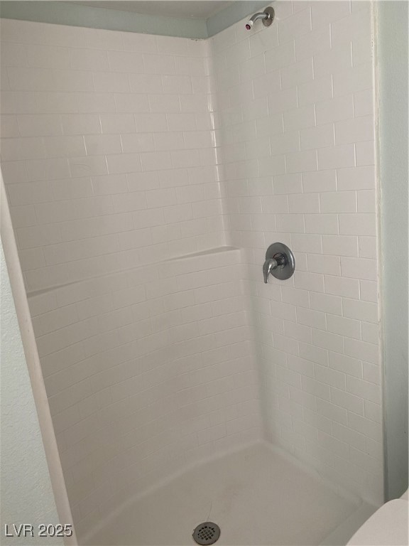 Full bath featuring toilet and a stall shower