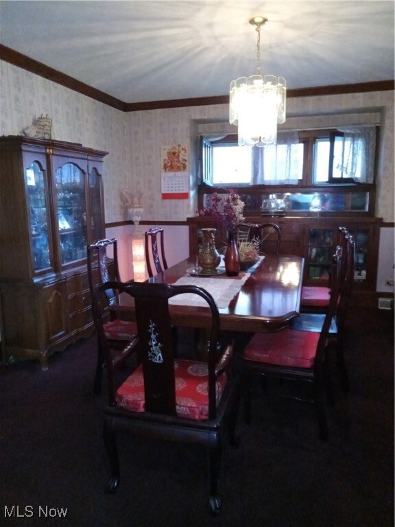 Dining space featuring an inviting chandelier and ornamental molding