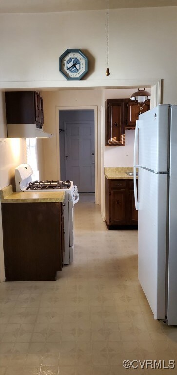 Kitchen with white appliances and dark brown cabin