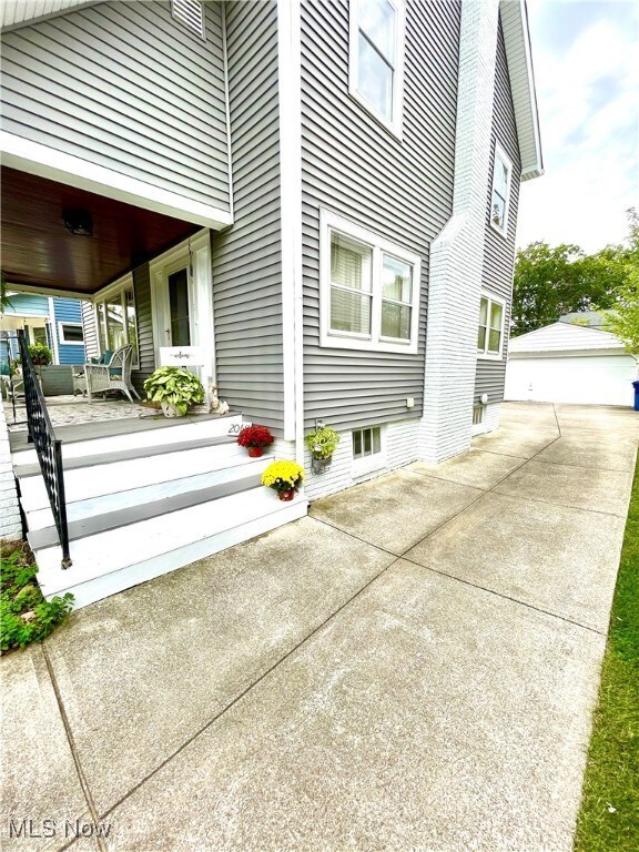 View of home's exterior featuring new siding, with concrete drive and two car garage