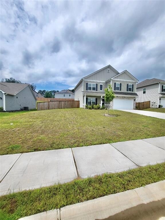 View of front facade featuring an attached garage, board and batten siding, and driveway