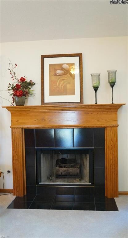 A gas fireplace w/ tile surround and wood mantle i