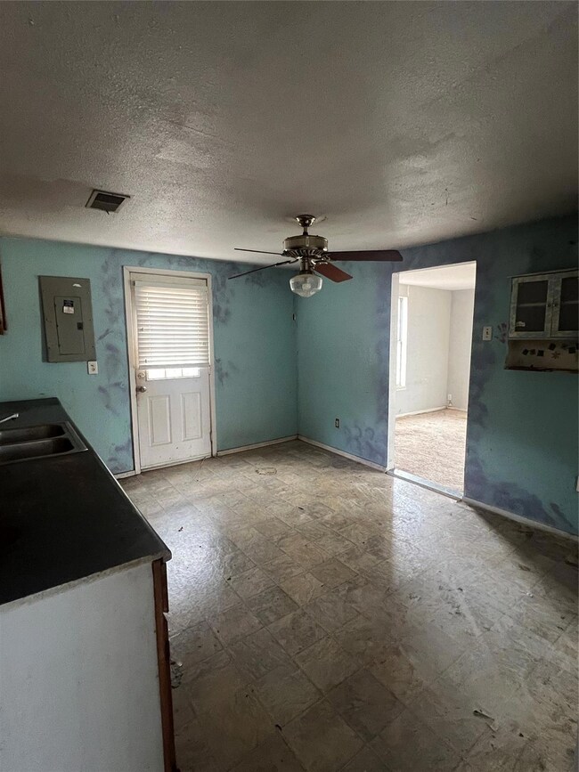 Unfurnished living room with sink, a textured ceil