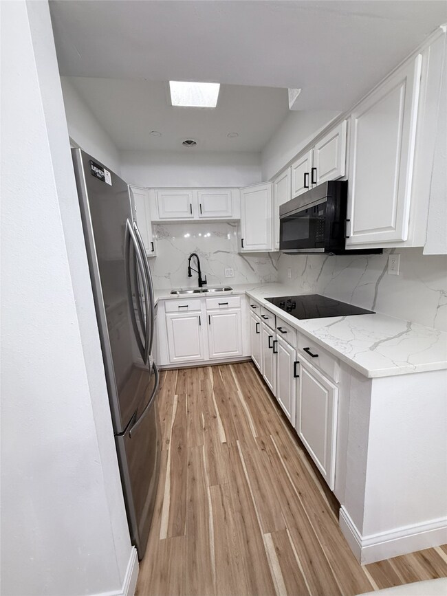 Updated appliances and modern lighting make this kitchen both stylish and efficient.