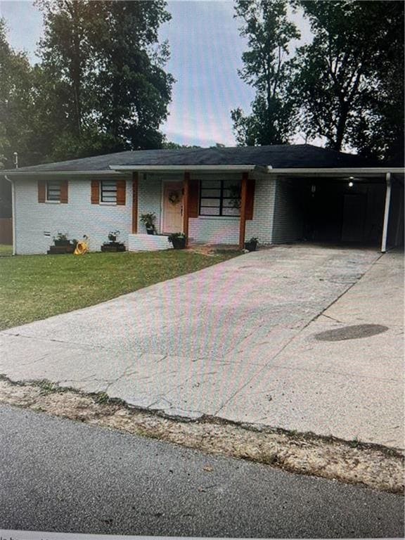 Ranch-style home featuring driveway, brick siding, an attached carport, and covered porch