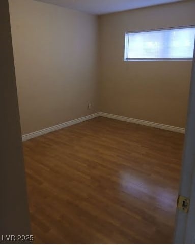 Empty room featuring wood finished floors and base