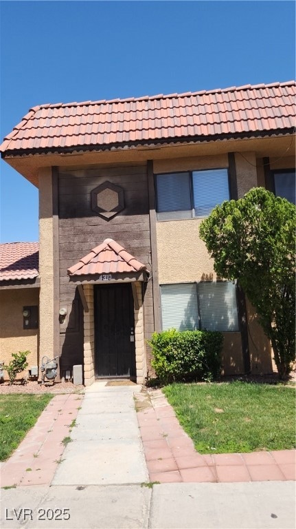 View of front of house featuring a tile roof and s