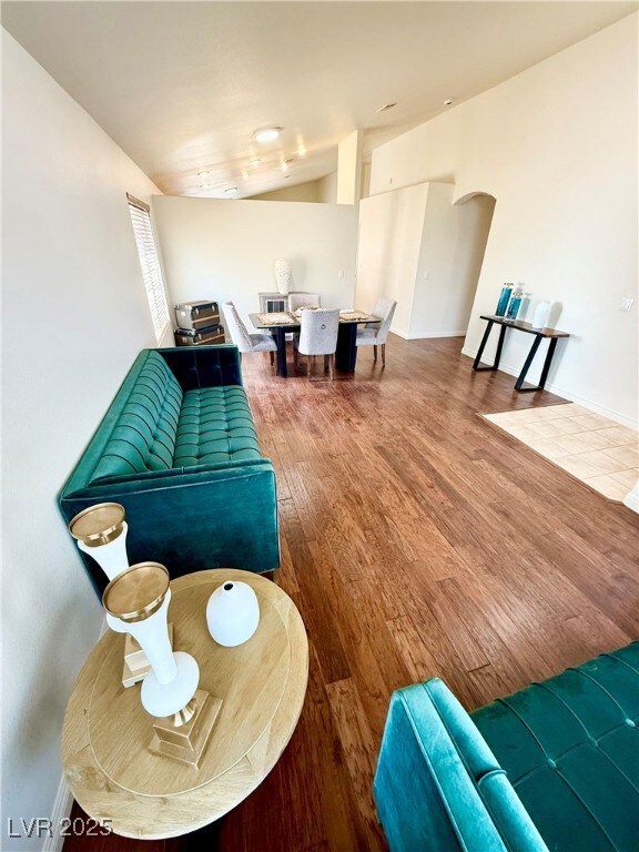 Living room featuring arched walkways, wood finish