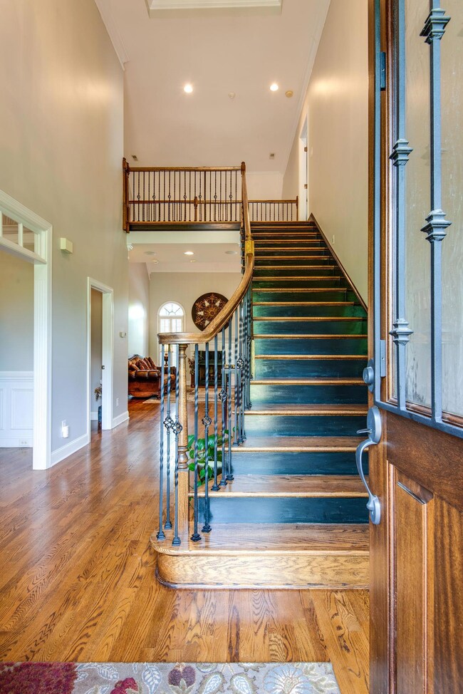 Beautiful Entry Foyer Boasts One Of Two Staircases Leading To The Second Floor. Wood Treads With Iron Railings Add a Touch of Flair.