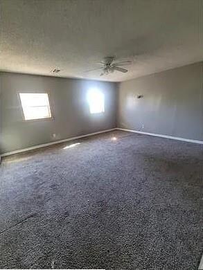 Carpeted empty room with ceiling fan