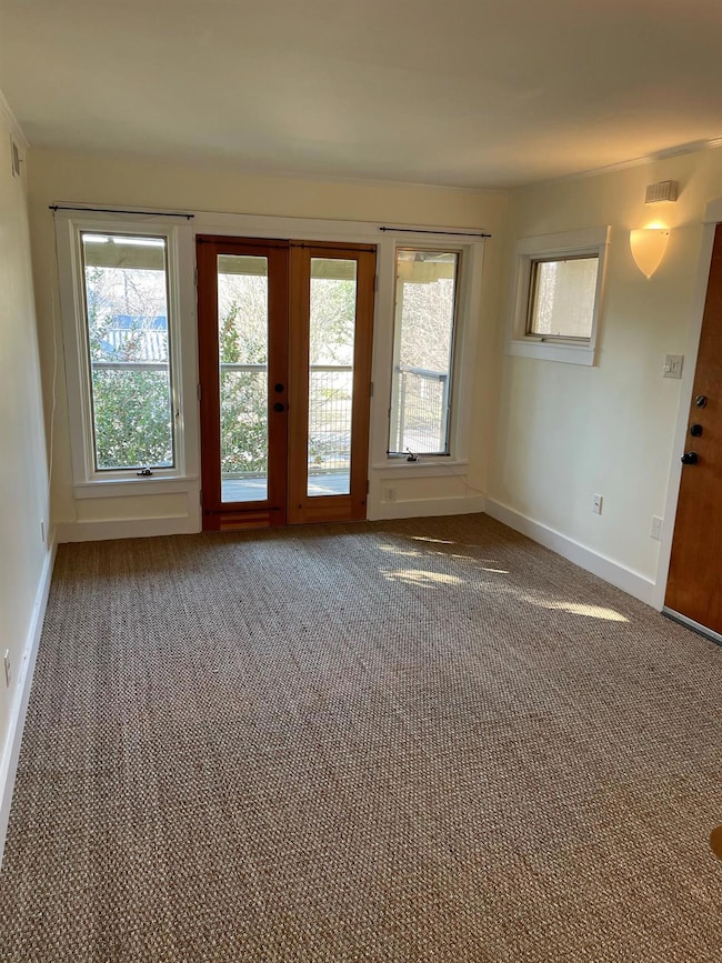 Carpeted empty room featuring baseboards and visi