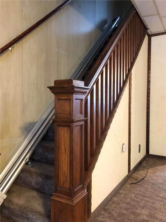 The pretty wood bannister features a newel post th