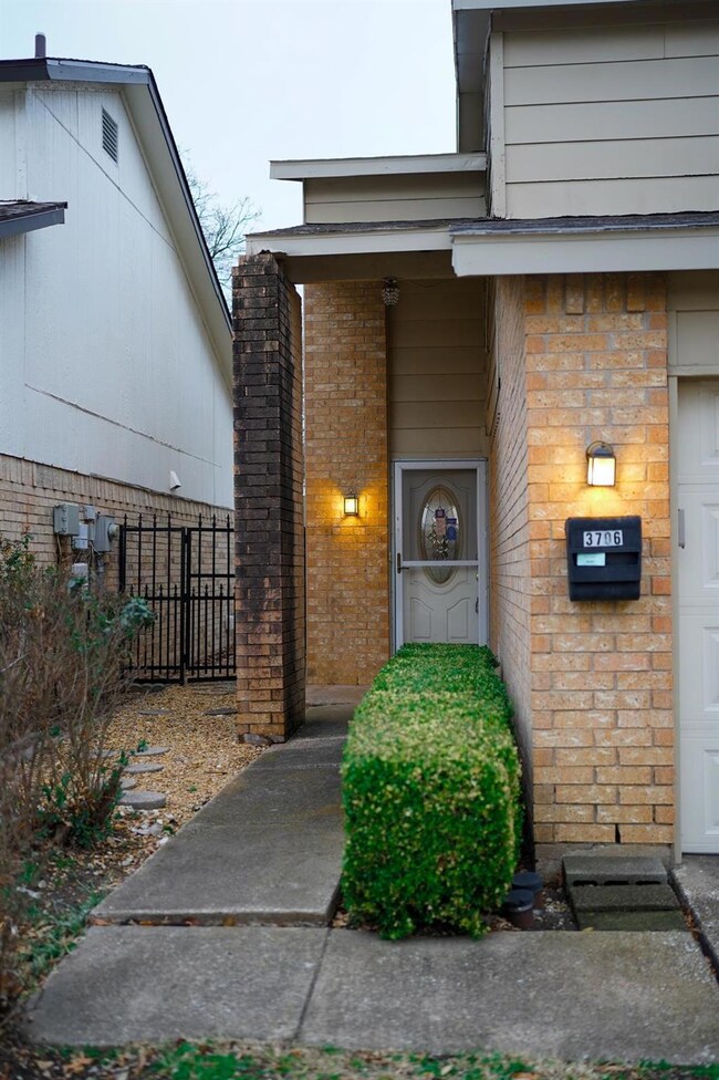 Doorway to property with a garage, brick siding, a