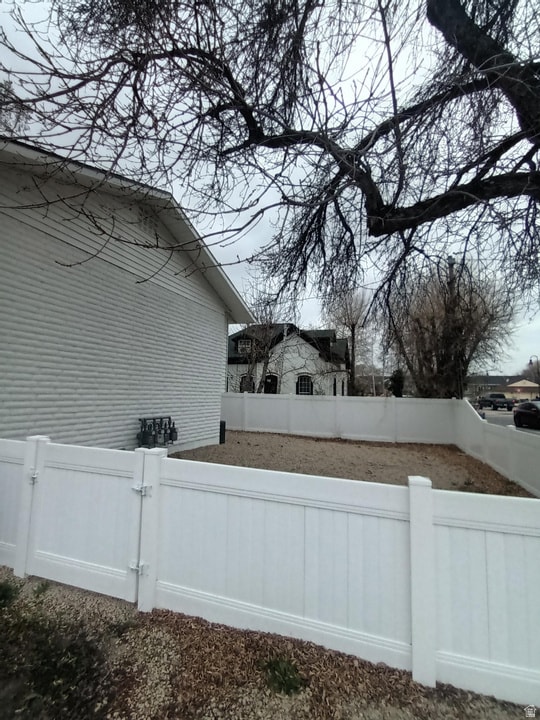 View of property exterior featuring a fenced backyard and a gate