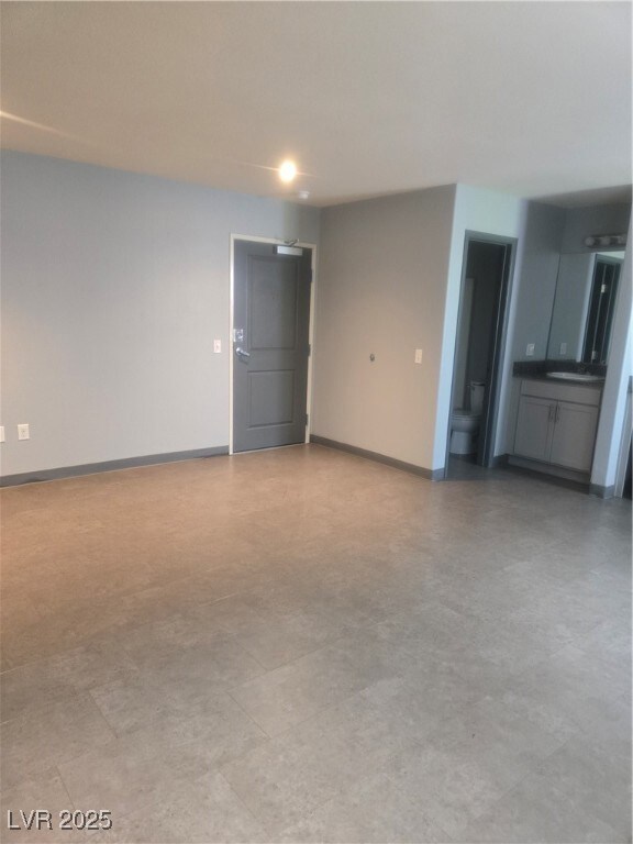 Empty room featuring baseboards and a sink
