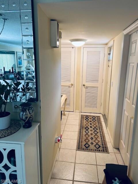 Corridor with baseboards and light tile patterned 
