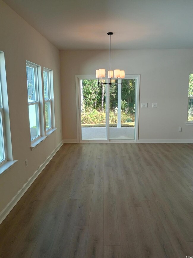 Unfurnished dining area with dark wood-type floori
