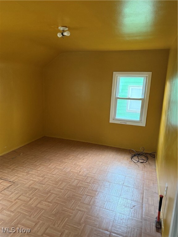 Bonus room featuring vaulted ceiling and baseboards