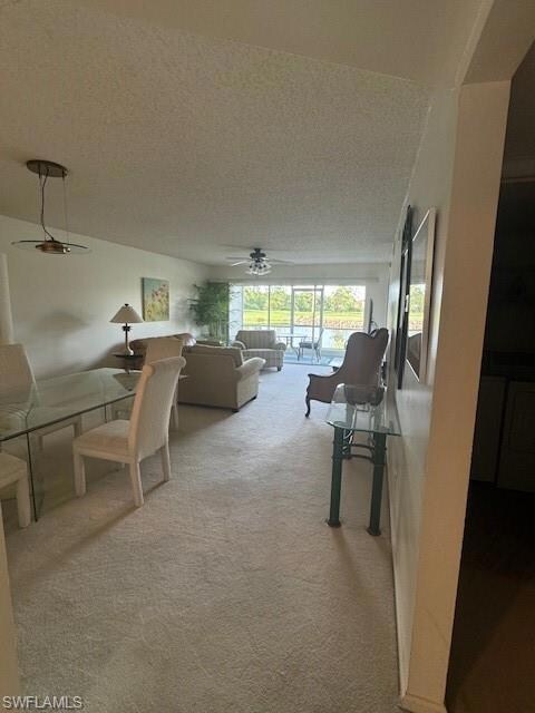 Carpeted living room with ceiling fan and a textur