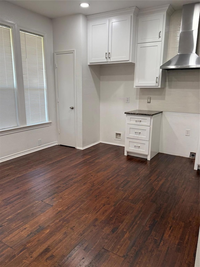Kitchen featuring white cabinetry, ventilation hoo