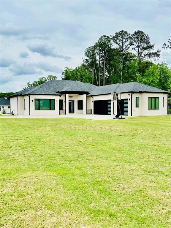 Back of property with a lawn and a garage