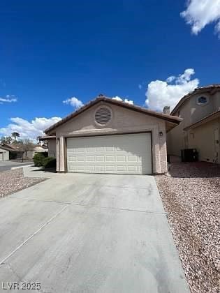 View of front of home featuring driveway, an attac