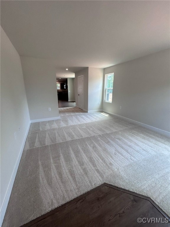 Unfurnished living room featuring baseboards and l