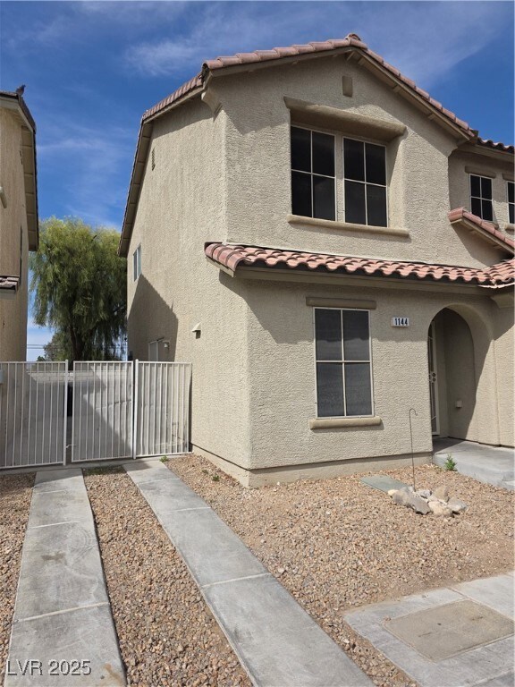 View of front of house with fence, a tiled roof, a