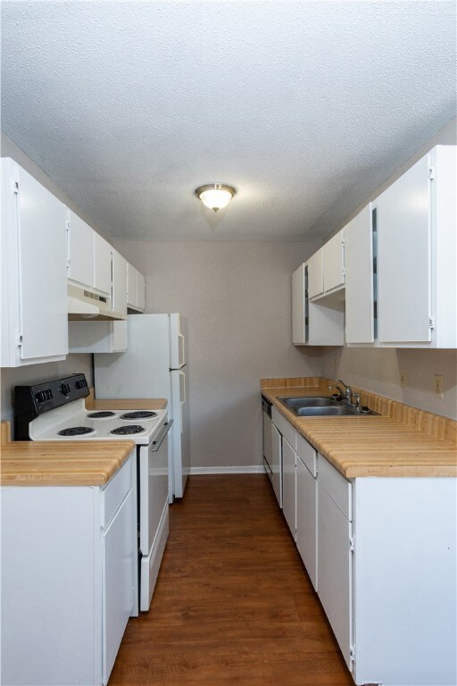 Kitchen featuring under cabinet range hood, white