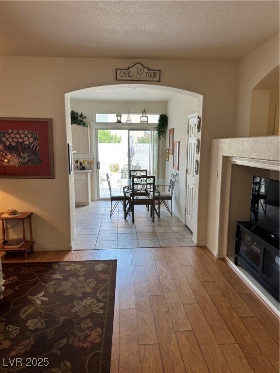 Dining area featuring arched walkways, light wood-