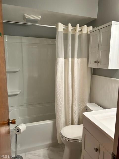 Full bathroom with tile floors, toilet, shower / tub combo with curtain, and vanity