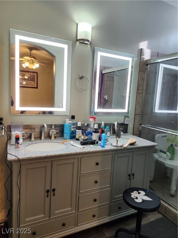 Full bath with double vanity, tiled shower, and a
