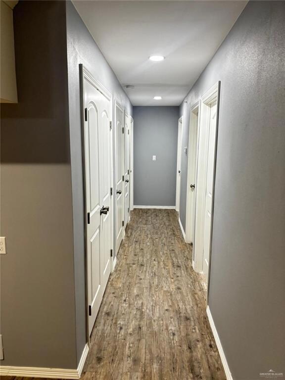 Corridor with baseboards and wood finished floors