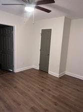 Empty room with a ceiling fan, baseboards, and wood finished floors