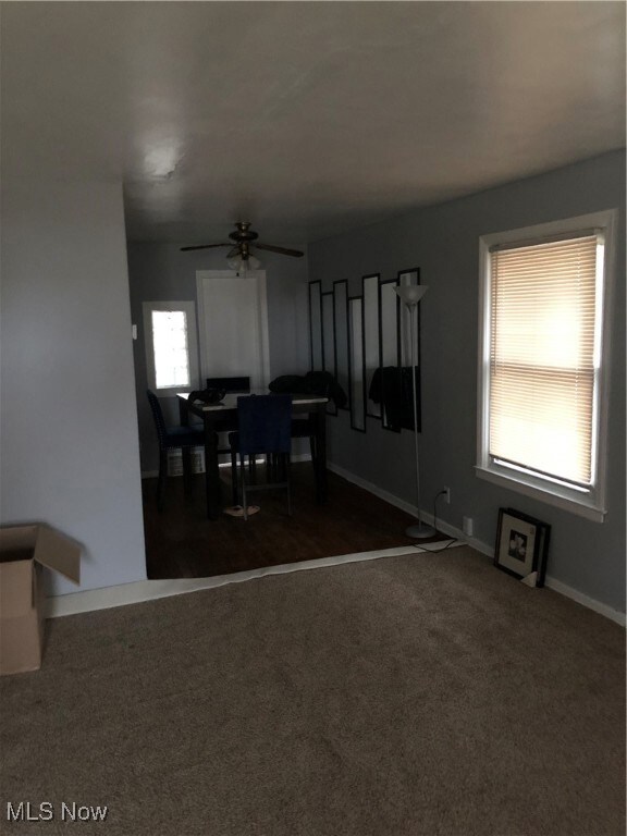 Dining area featuring dark carpet and baseboards
