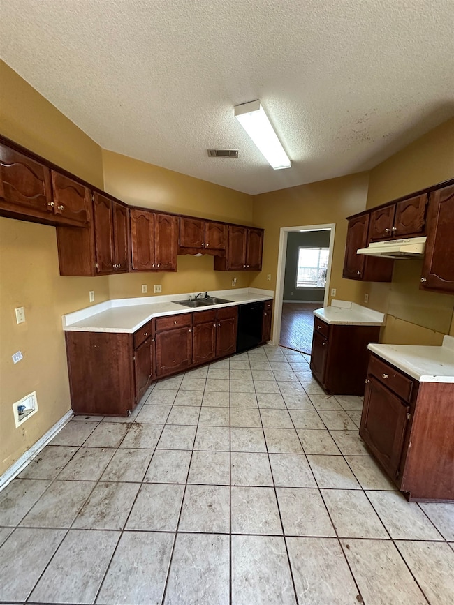 Kitchen with light tile patterned floors, a textur