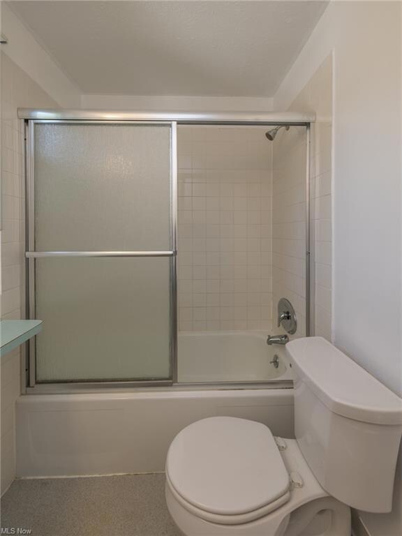 Bathroom with bath / shower combo with glass door 