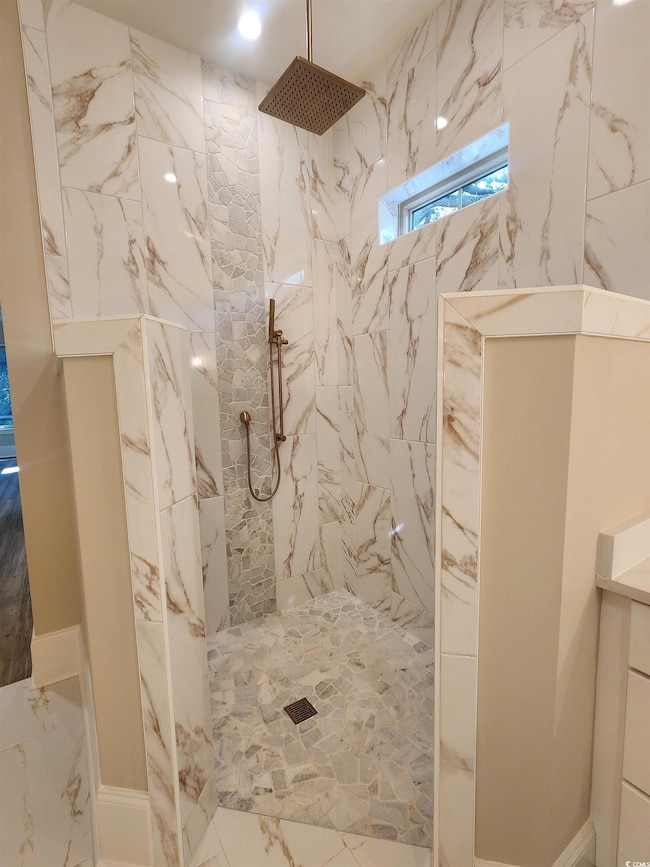 Full bath featuring a marble finish shower