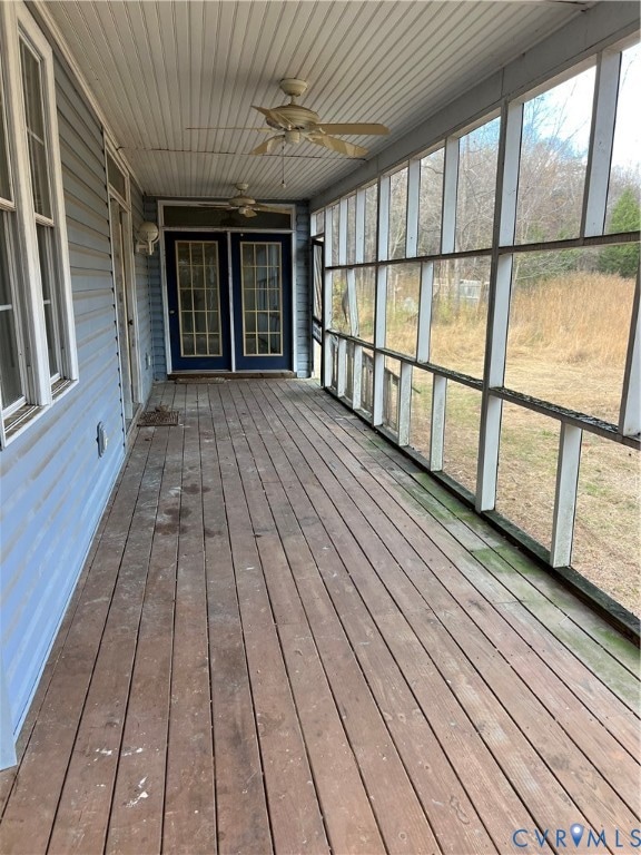 Wrap around screen porch featuring a ceiling fan